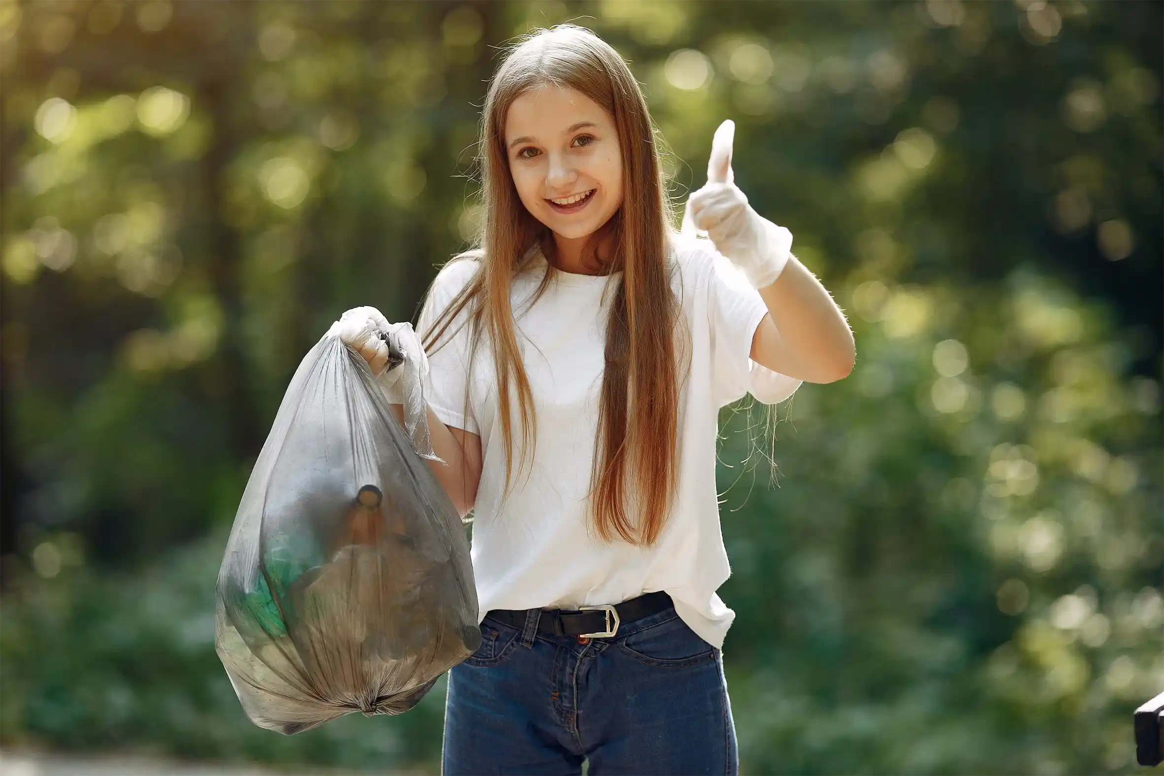 girl-collects-garbage-in-garbage-bags-in-park